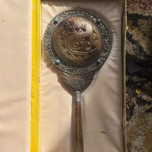Ornate Chinese jade and silver hand mirror with turquoise accents.